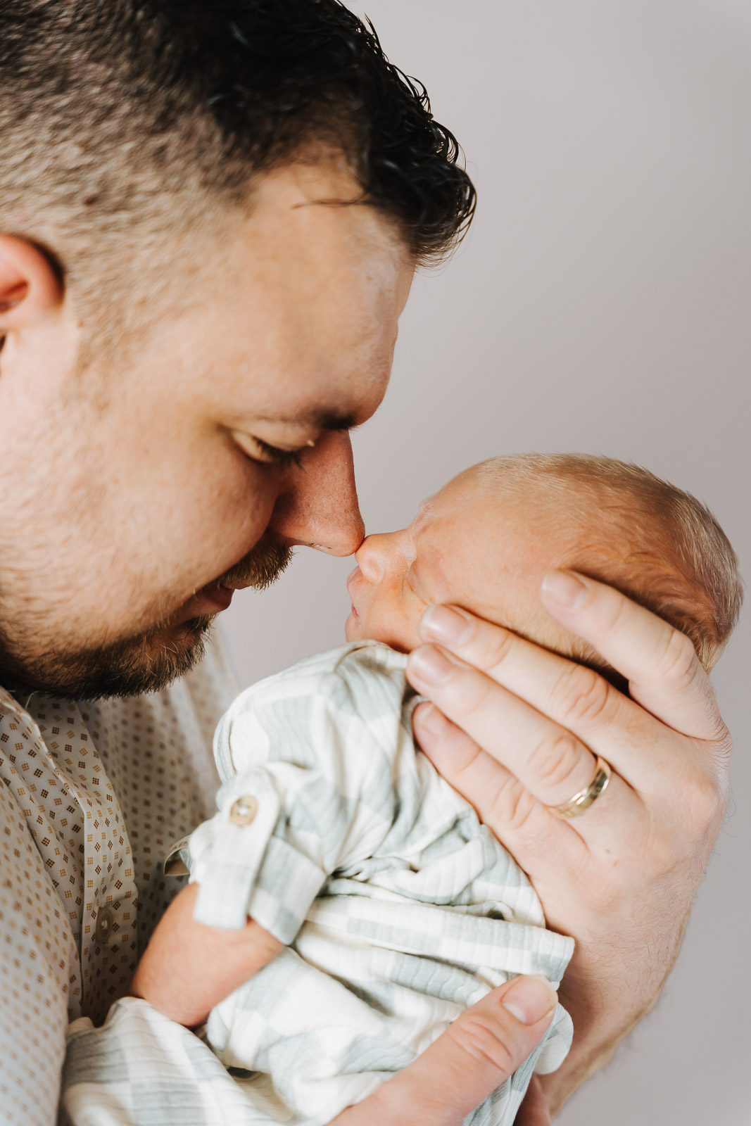 Papa houdt zijn pasgeboren baby dicht tegen zich aan, newbornfotograaf Wichelen