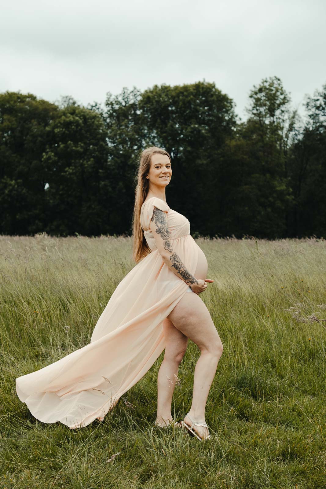 Zwangere mama in lichtroze jurk in het gouden gras, zwangerschapsfotograaf Wichelen