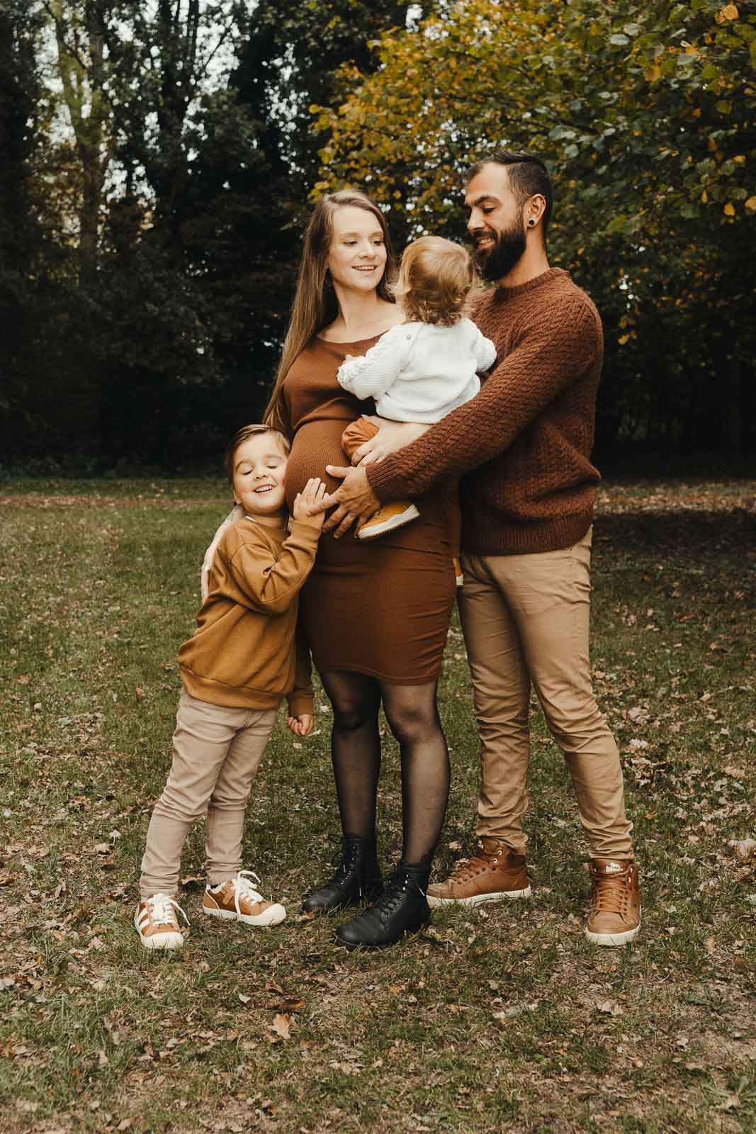 Gezin in herfsttinten met zwangere mama in het bos, zwangerschapsshoot in Wichelen